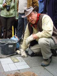 Gunter Demnig vor den von ihm verlegten „Stolpersteinen“.